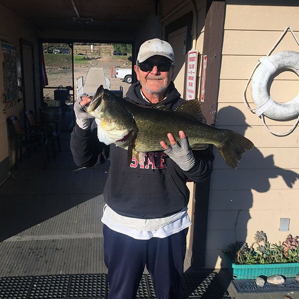 Angler displaying fish caught at reservoir lake