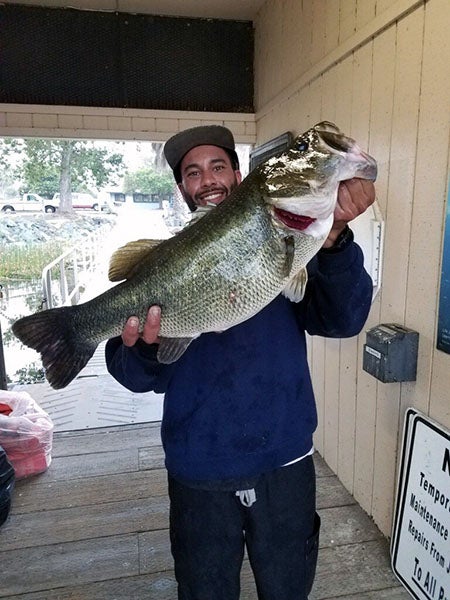 Angler displaying fish caught at reservoir lake