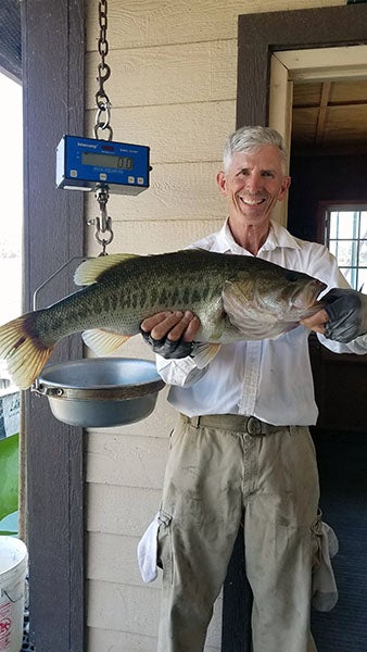 Angler displaying fish caught at reservoir lake