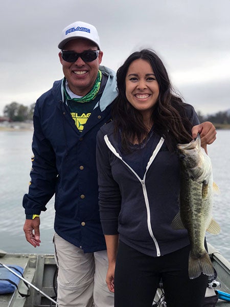 Anglers displaying fish caught at reservoir lake