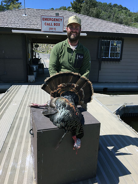 Hunter displaying turkey caught at reservoir lake