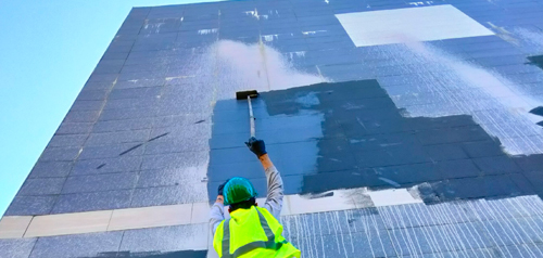 worker painting over graffiti