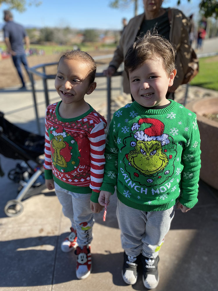 photo of two children wearing Christmas sweaters