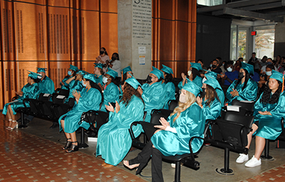 Graduates sitting down and clapping