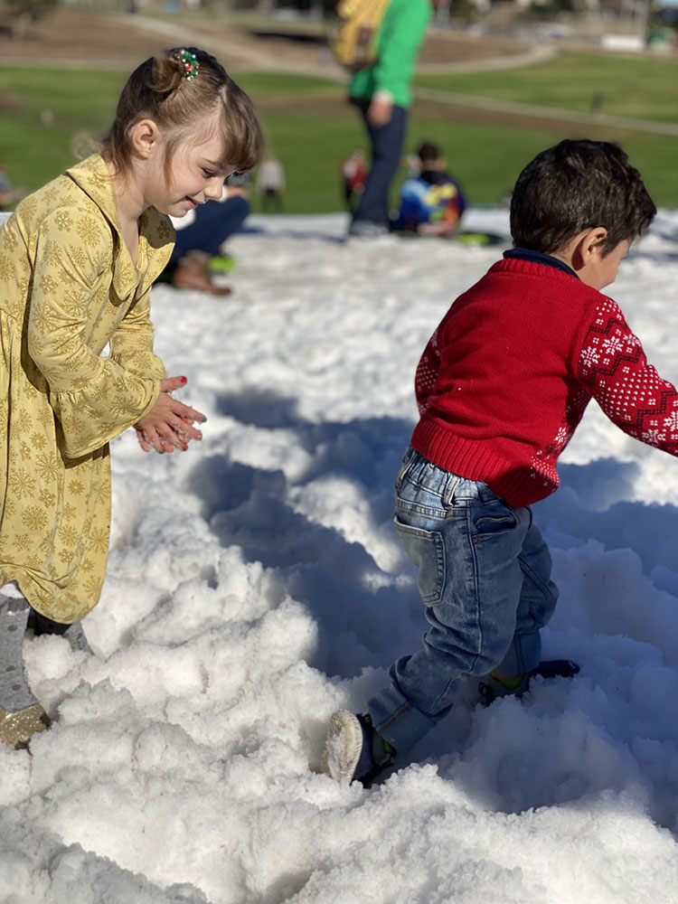 photo of two children playing in the snow