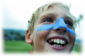 Picture of a boy laughing with blue paint over his nose