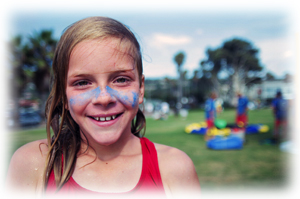 Picture of a girl smiling with blue paint over her cheeks