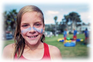 Picture of a girl smiling with blue paint over her cheeks