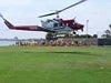 Picture of a helicopter landing on the field with kids in the background