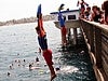 Boys and girls jumping into the water from the bridge