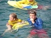 A boy helping the kids to swim