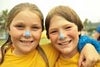 A picture of two girls with blue sunscreen on their nose