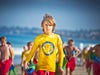 Picture of a boy in yellow shirt holding feather