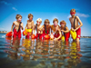 Image of seven kids standing in water