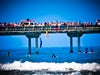 Kids jumping into the water from over the bridge