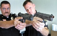 Photo of Police Officers Holding Real and Replicant Guns