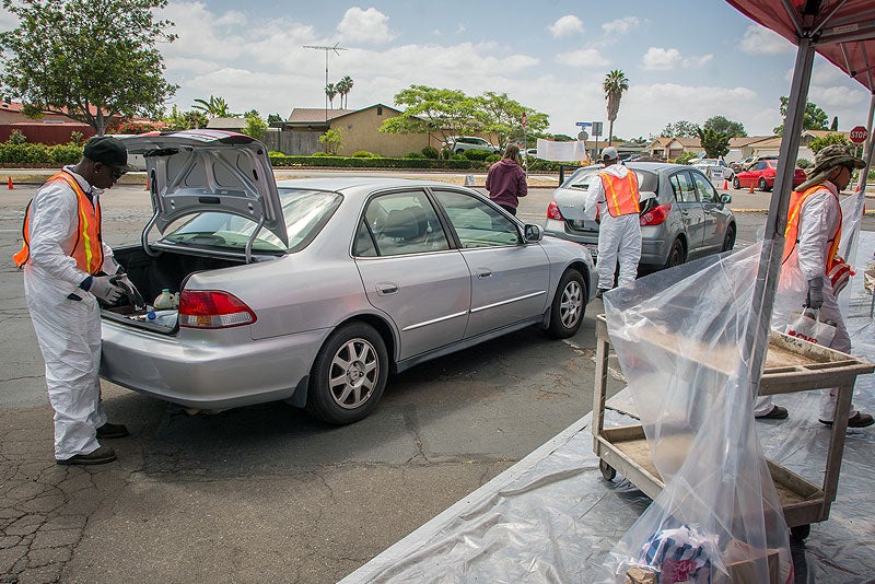 Workers collecting hazardous waste at a collection event