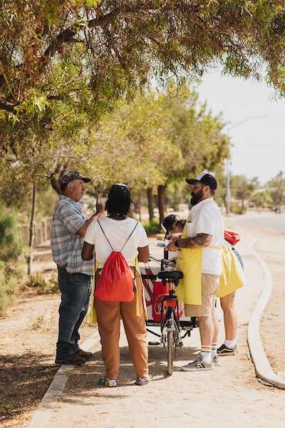 Mario Mesquita talking to San Diegans next to his vending tricycle