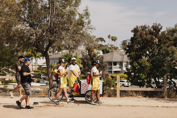 Mario Mesquita talking to San Diegans next to his vending tricycle