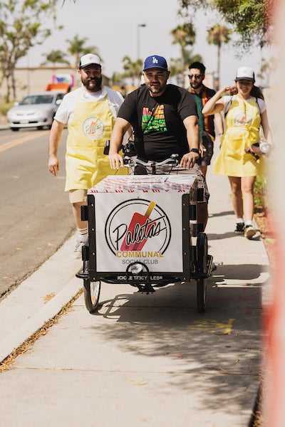 Mario Mesquita talking to San Diegans next to his vending tricycle
