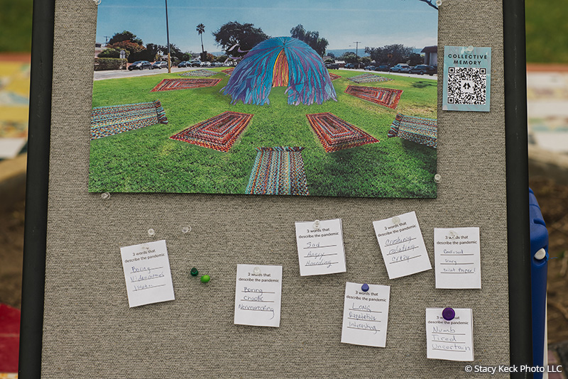 Bulletin board with a photo of the Collective Memory art installation and postings from visitors