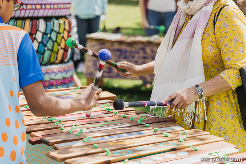 Two park visitors playing the xylophone art piece