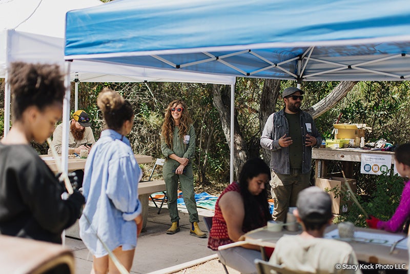 Park visitors getting information about the Collaboration with the Passerby art installation