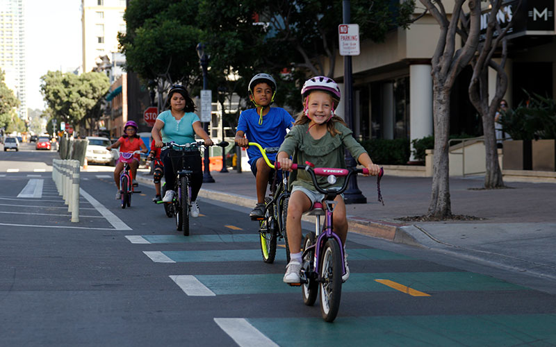 Children riding on a protected bike lane in downtown