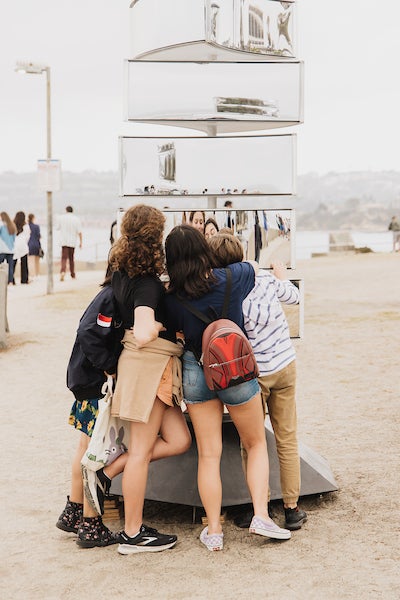 Park visitors interacting with a periaktoi composed of independently rotating mirrored sections