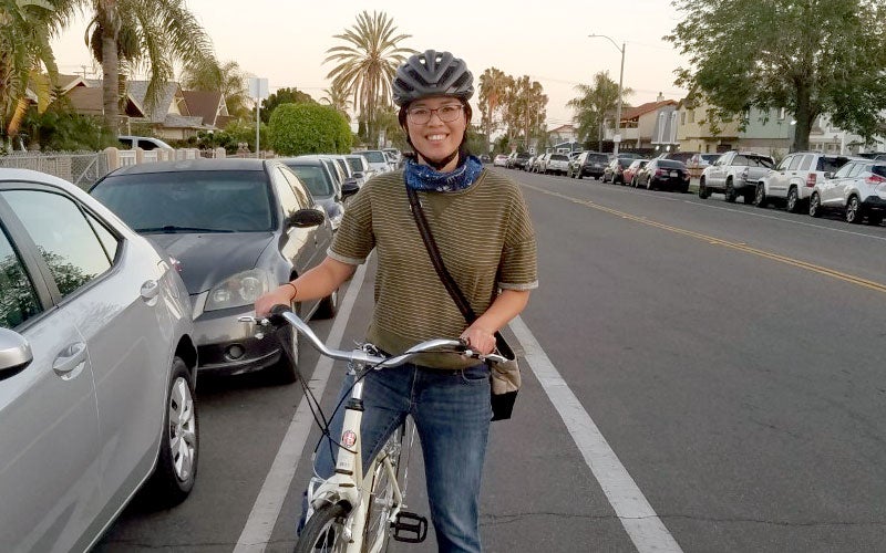 Andrea Deleon posing for a photo while sitting on a bike