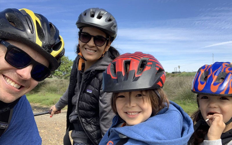 Colin Santulli and family members wearing bike helmets while smiling for a photo