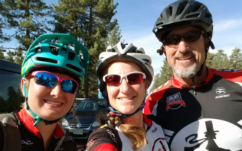 Lisa Hauck and family members wearing bike helmets while smiling for a photo