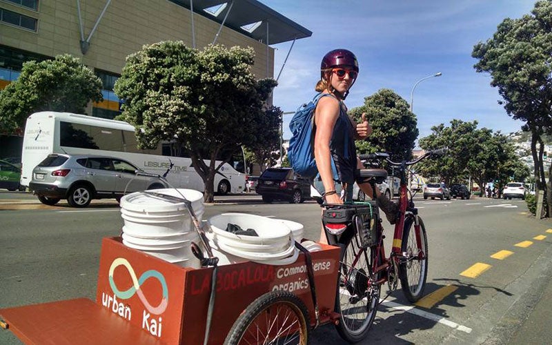 Sylvie Froncek is about to ride her bike that's towing an Urban Kai kart