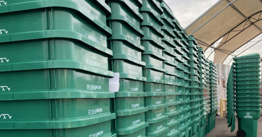 green recycling bins stacked in rows