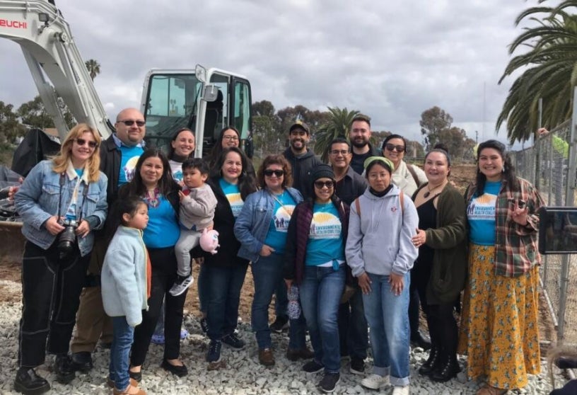 Members of the Environmental Health Coalition posing in front of a construction site