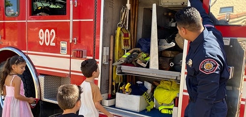 Firefighter giving children a tour of a fire truck