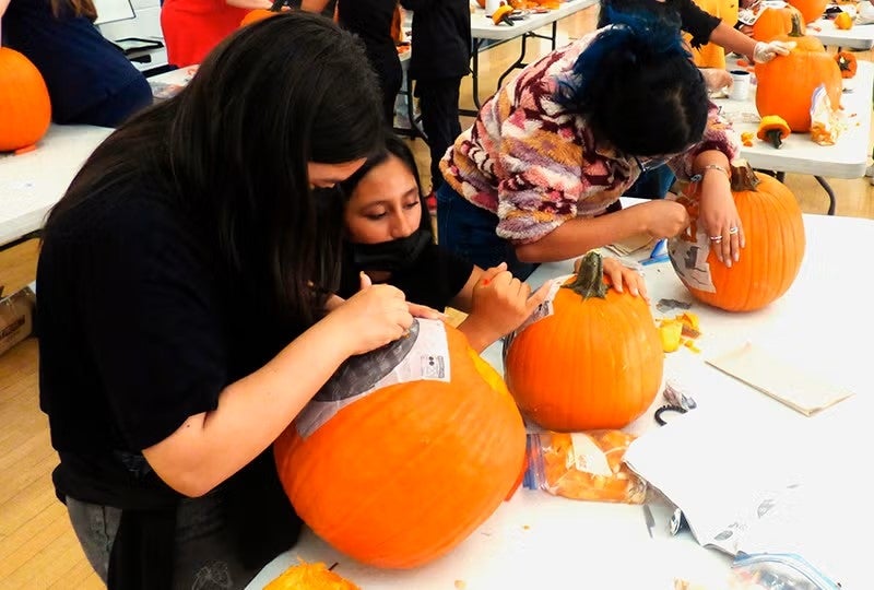 Kids carving pumpkins.