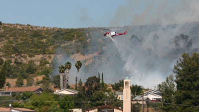 Helicopter dropping water over area