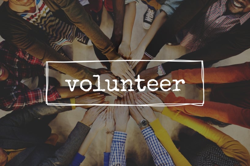 Photo of hands and the word Volunteer