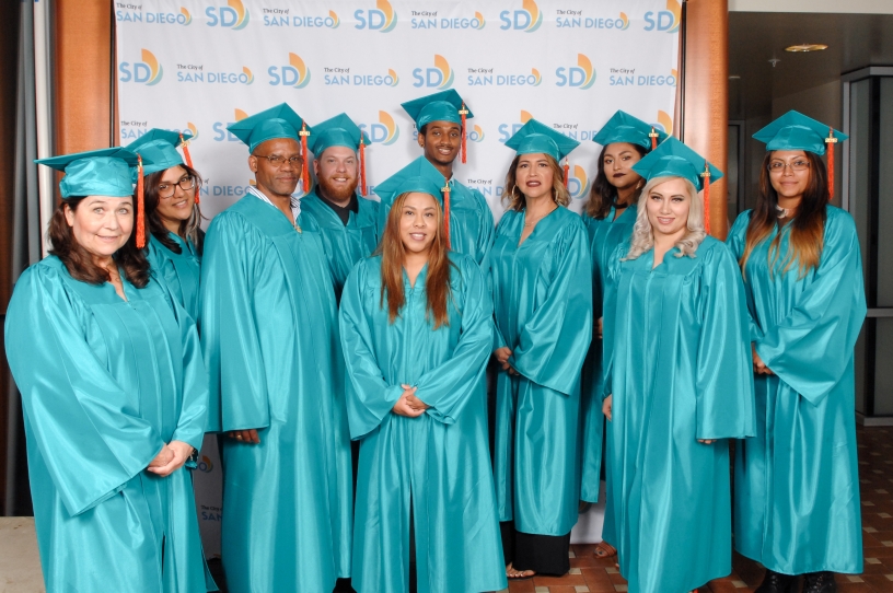 Students in teal graduation robes and caps