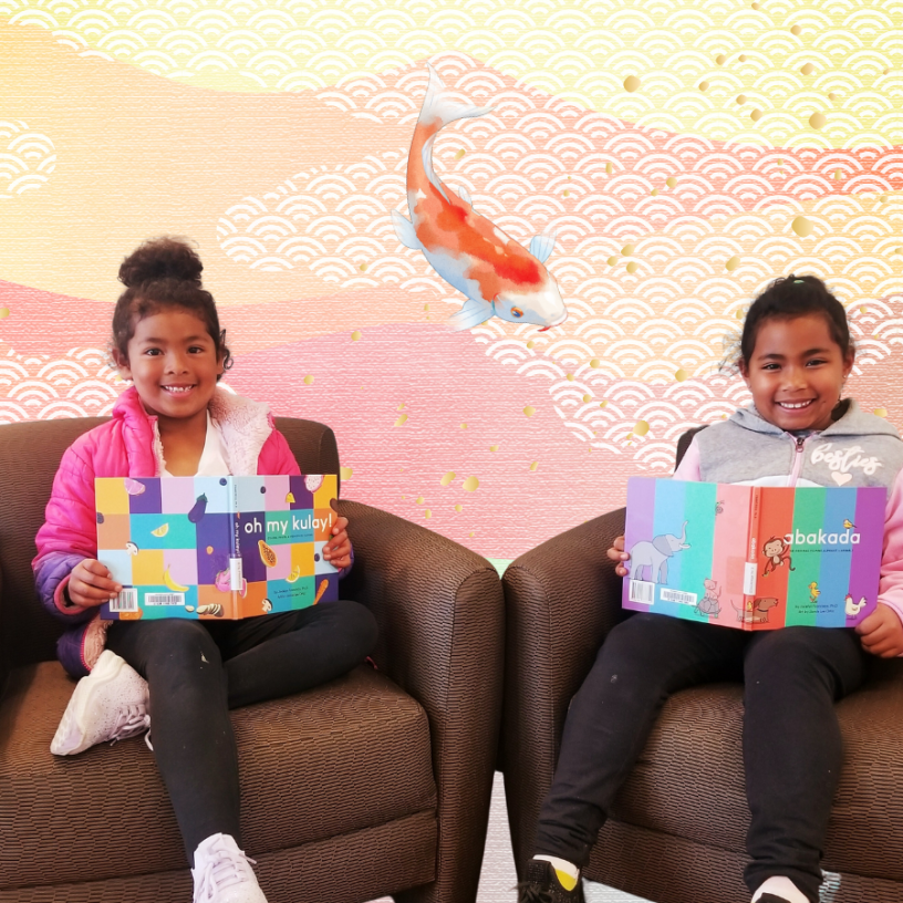 Children sitting down with open books