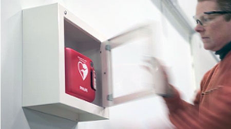 person opening wall mounted AED case