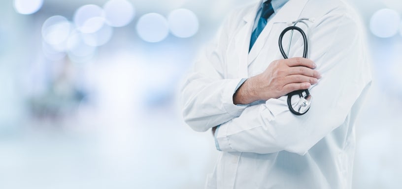 doctor with crossed arms holding a stethoscope 