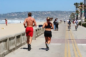 Photo of Couple Running on Boardwalk