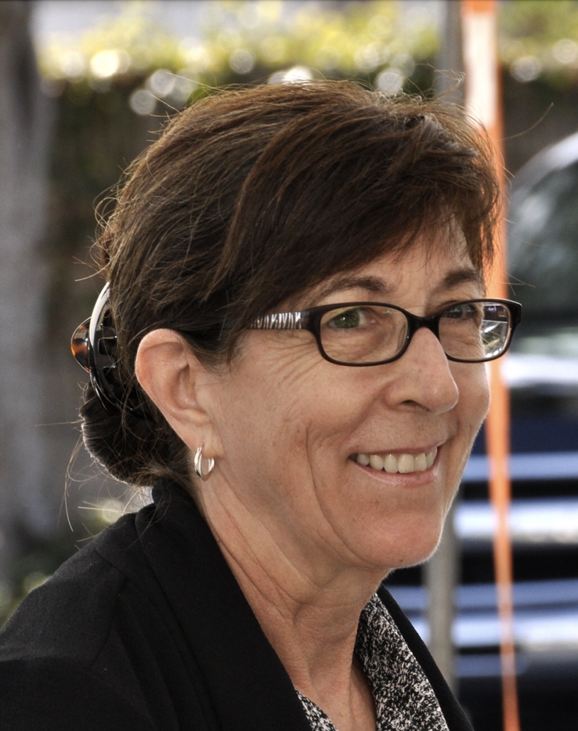 Brown haired woman in black glasses smiling, Cynthia Hughes Doyle.
