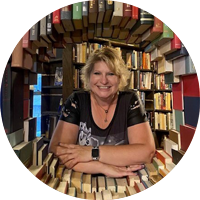 Photo of librarian smiling in a circle of books