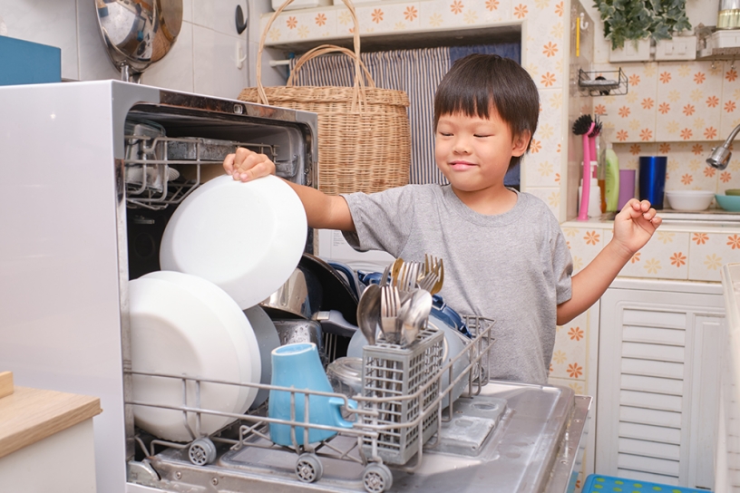 child loading a dishwasher