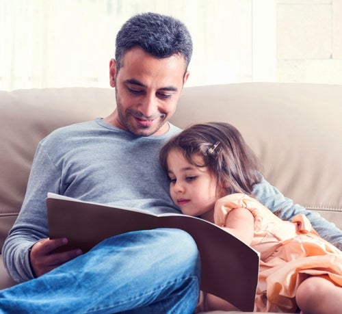 Father reading book to young daughter.