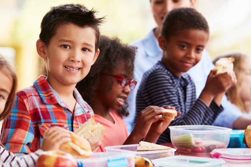 Kids smiling and eating lunch