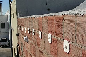 Steel bolts tie the unreinforced masonry walls to the floor of a building.